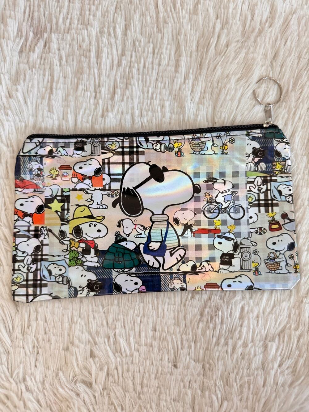 Snoopy pencil case with multiple poses and outfits on a plaid background black